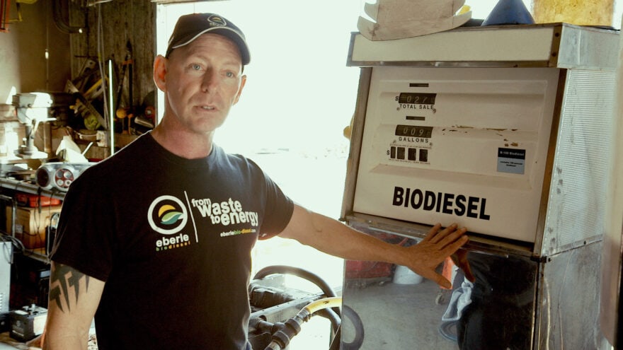 A man standing next to a biodiesel gas dispenser